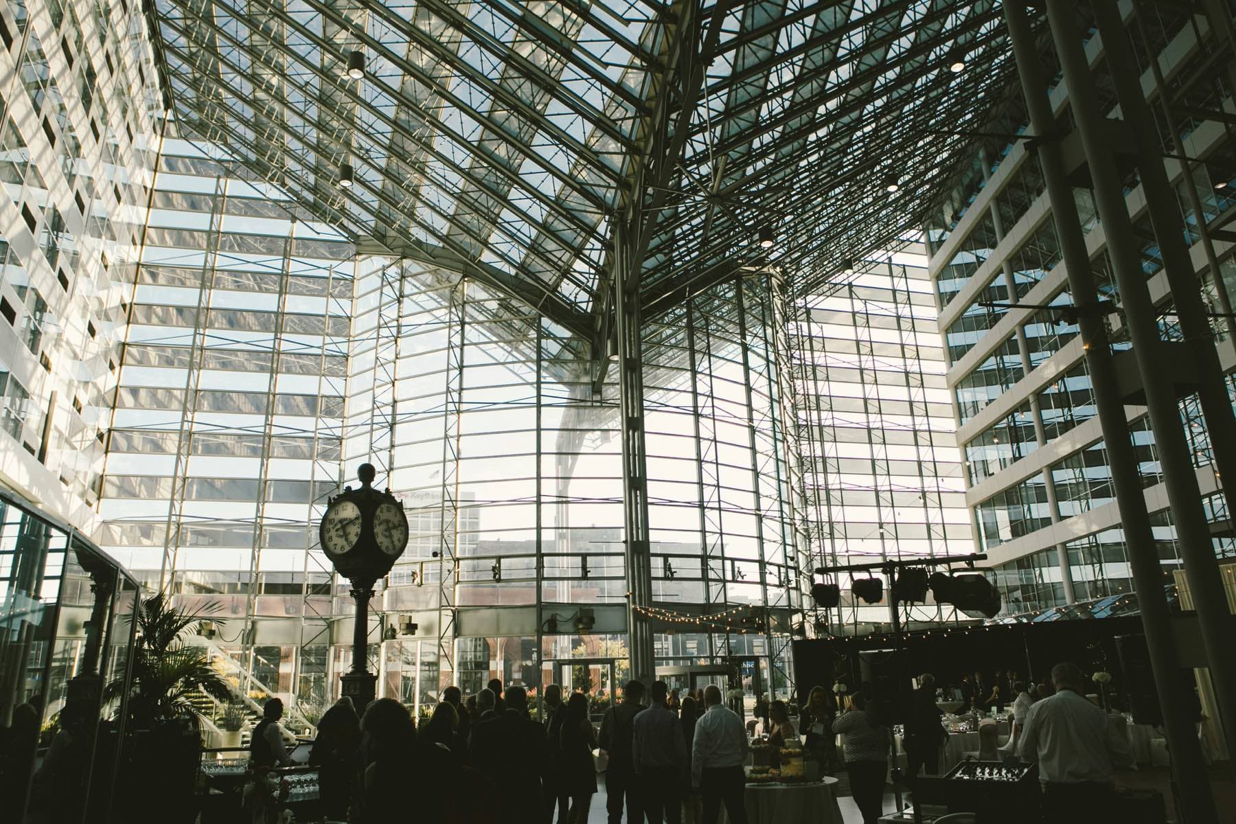 People walking through a bright glass-roofed atrium in daylight
